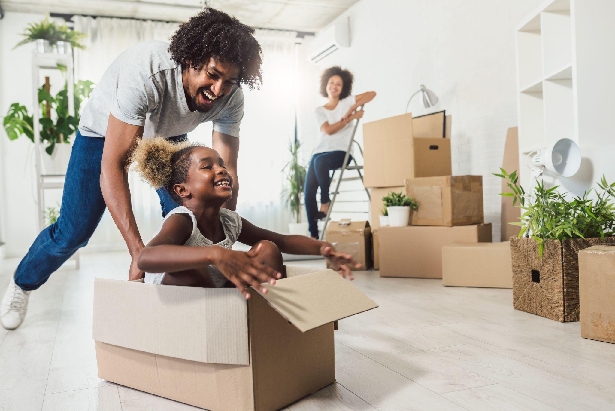 family excitedly unpacking belongings after moving to new house