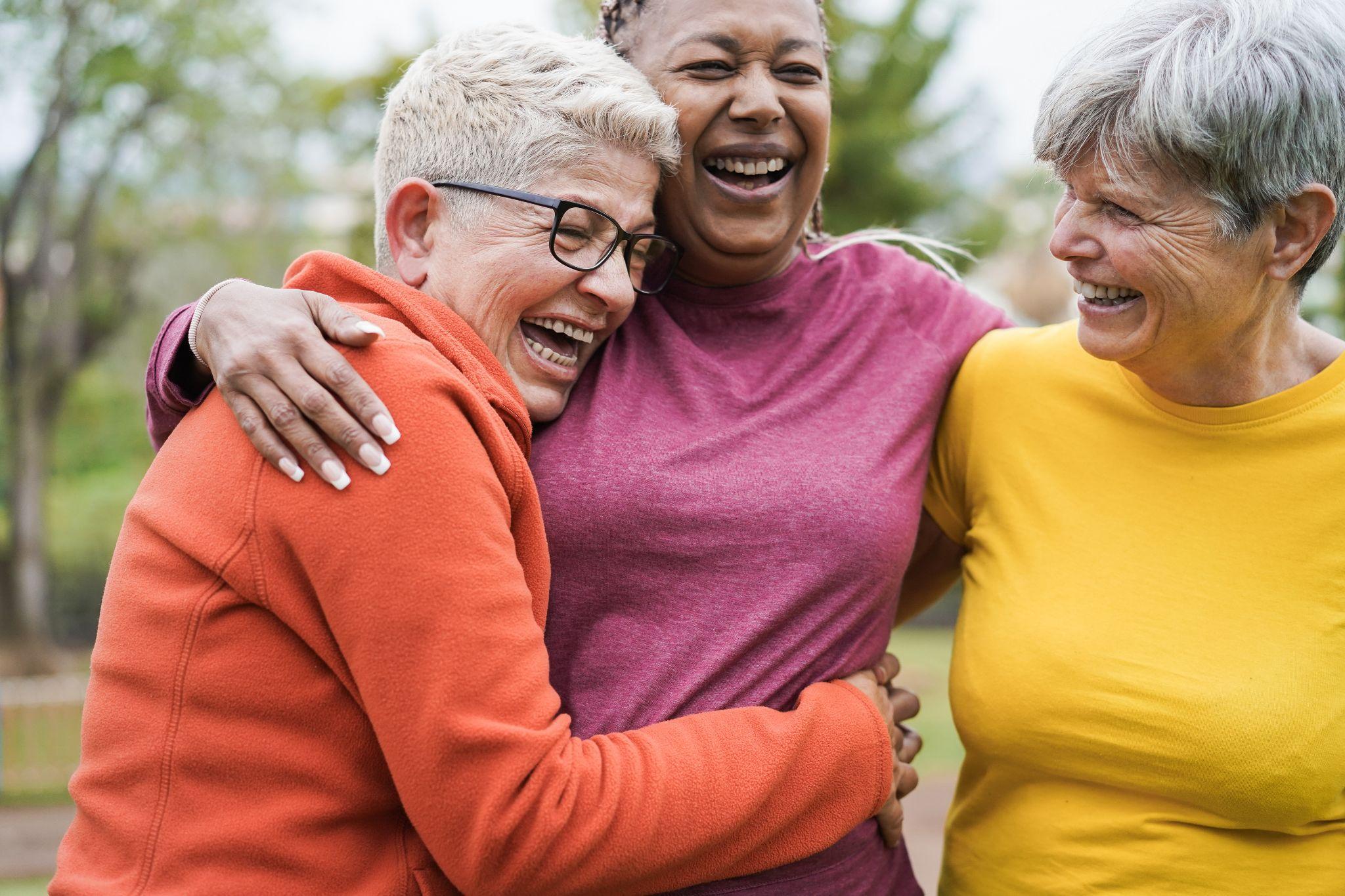 Multiracial senior women having fun together hugging each others